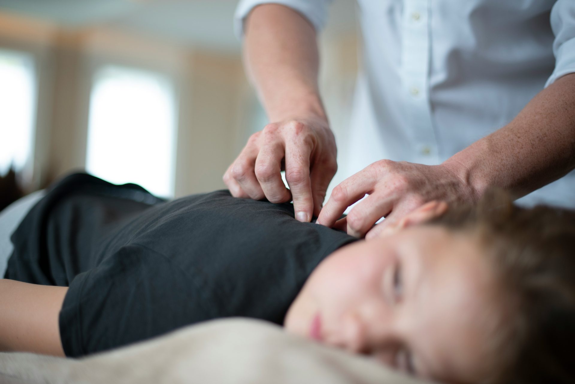 a woman getting a massage from a man in a white shirt